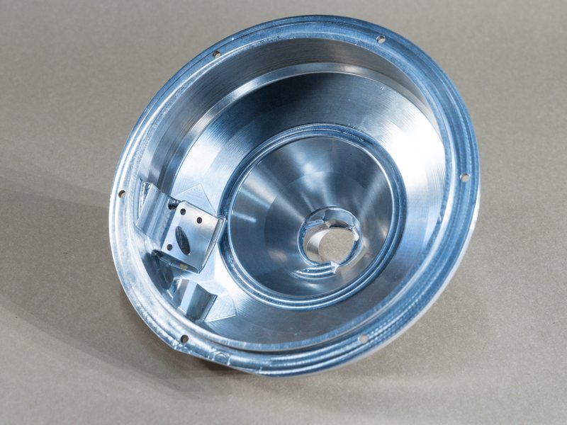 Large round housing with a conical bore, a bolt-circle flange, and milled pockets